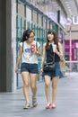 Two young girls walk in a shopping mall, Beijing, China